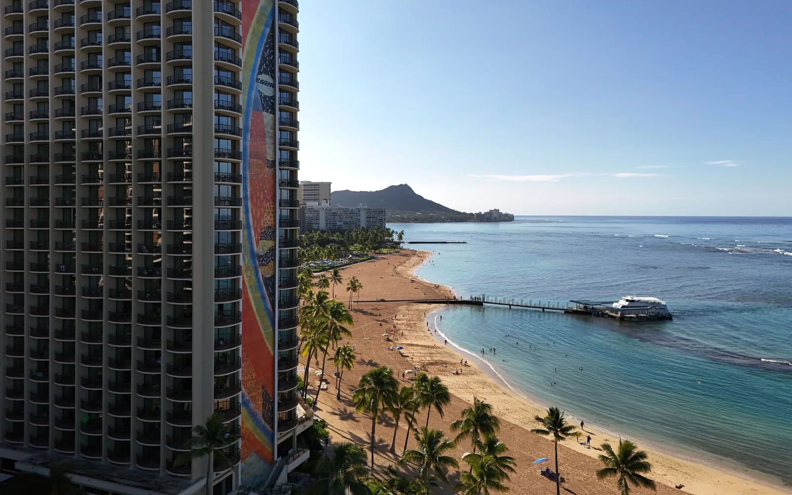 Waikiki Beach'in hemen yanındaki Hilton Hawaiian Village'in Rainbow Tower'ına kuş bakışı bir görünüm; uzakta Diamond Head